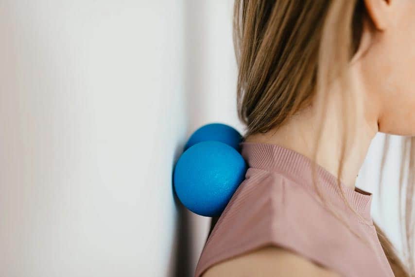 Physiotherapy with blue massage ball for neck pain