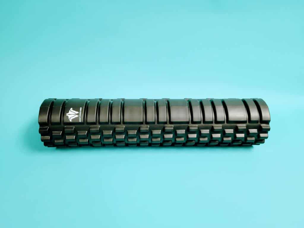 Black textured foam roller on a blue background