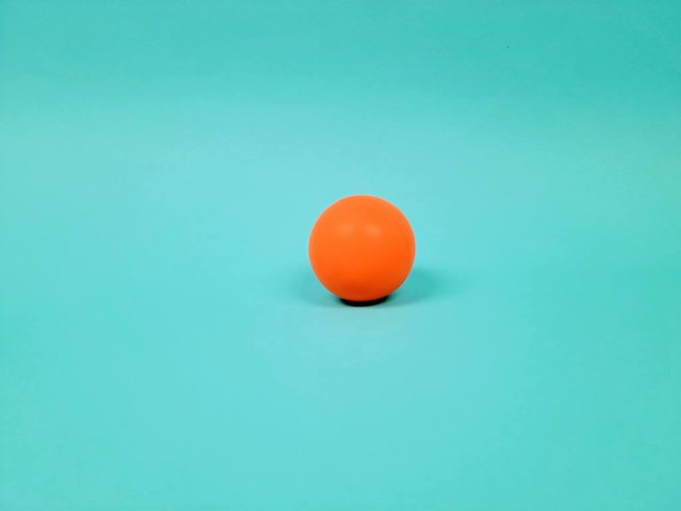 Orange exercise ball on blue background