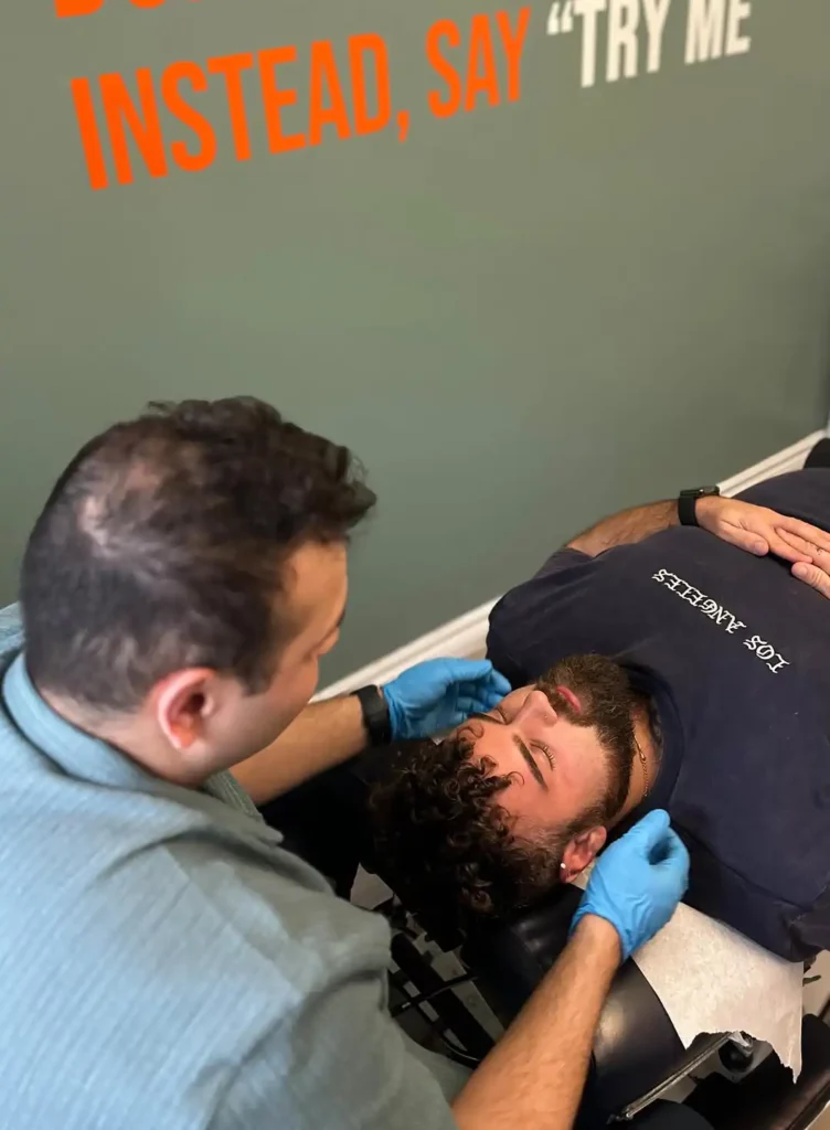 Chiropractor supporting a side-lying patient's neck during treatment