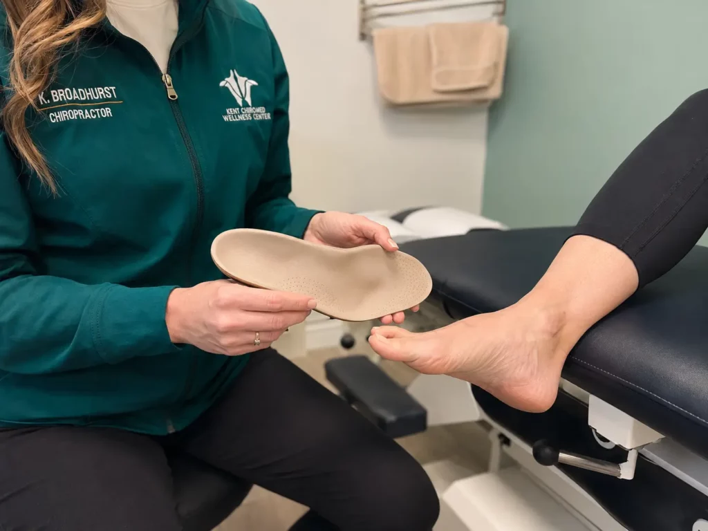 Dr Courtney Broadhurst assessing a patients foot with a custom orthotic at Kent Chiro Med Wellness Clinic in Ottawa