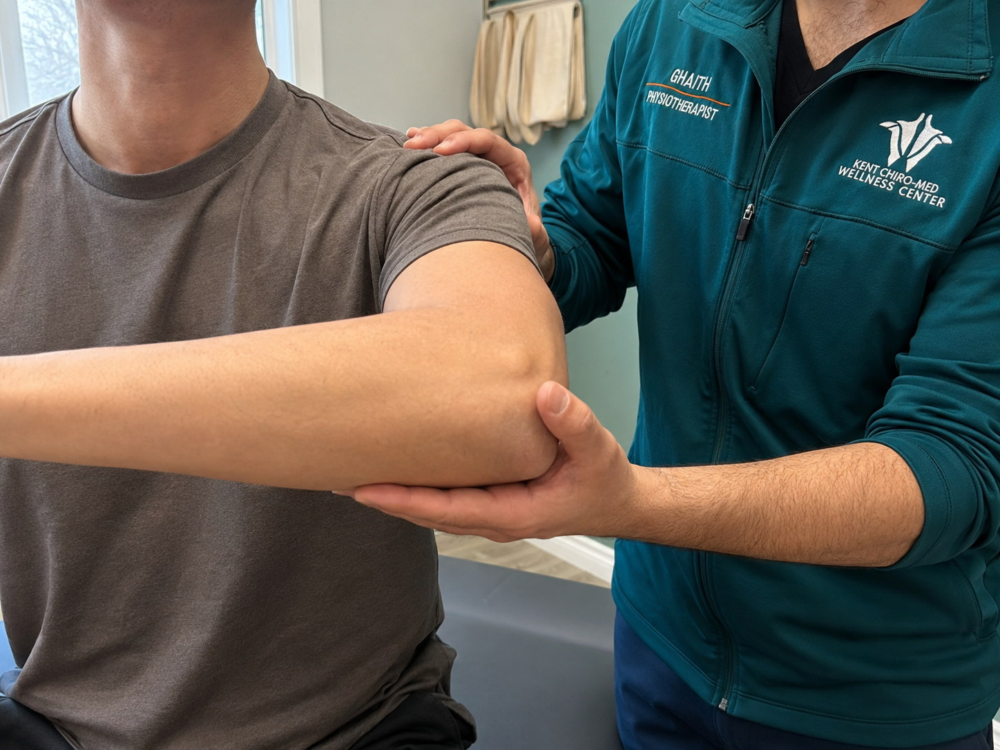 Ghaith Dhaidan assessing a patients shoulder and arm mobility for pain relief treatment at Kent Chiro Med Wellness Clinic in Otta