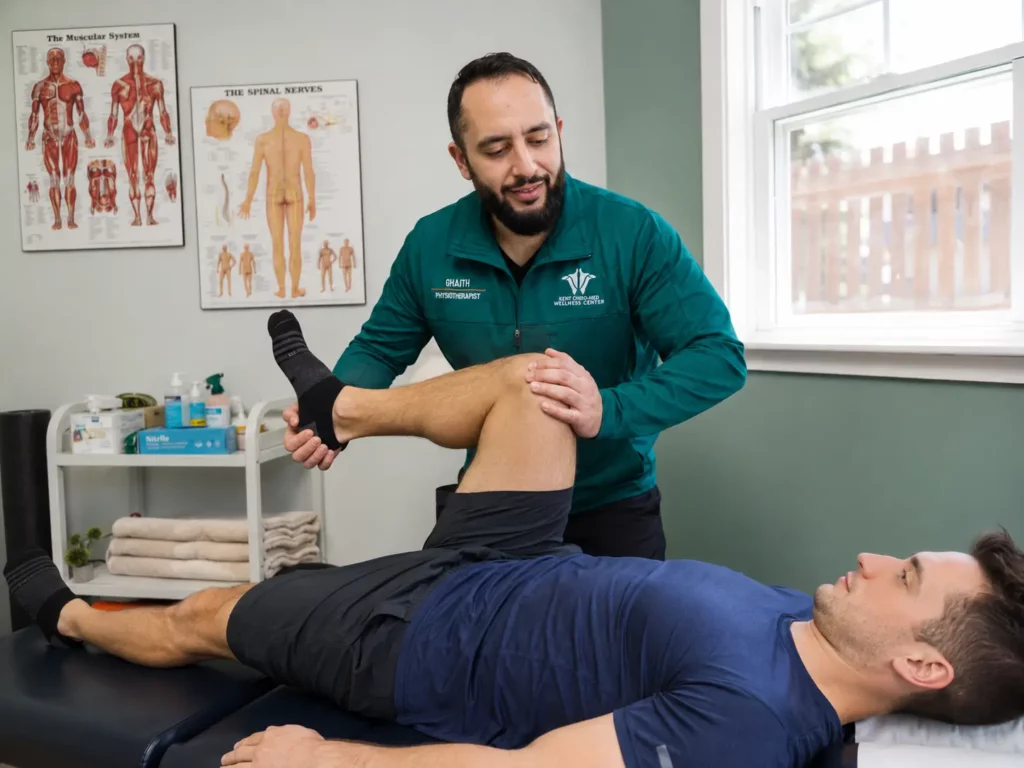 Ghaith Dhaidan providing guided leg and hip mobilization treatment to a patient at Kent Chiro Med Wellness Clinic in Ottawa