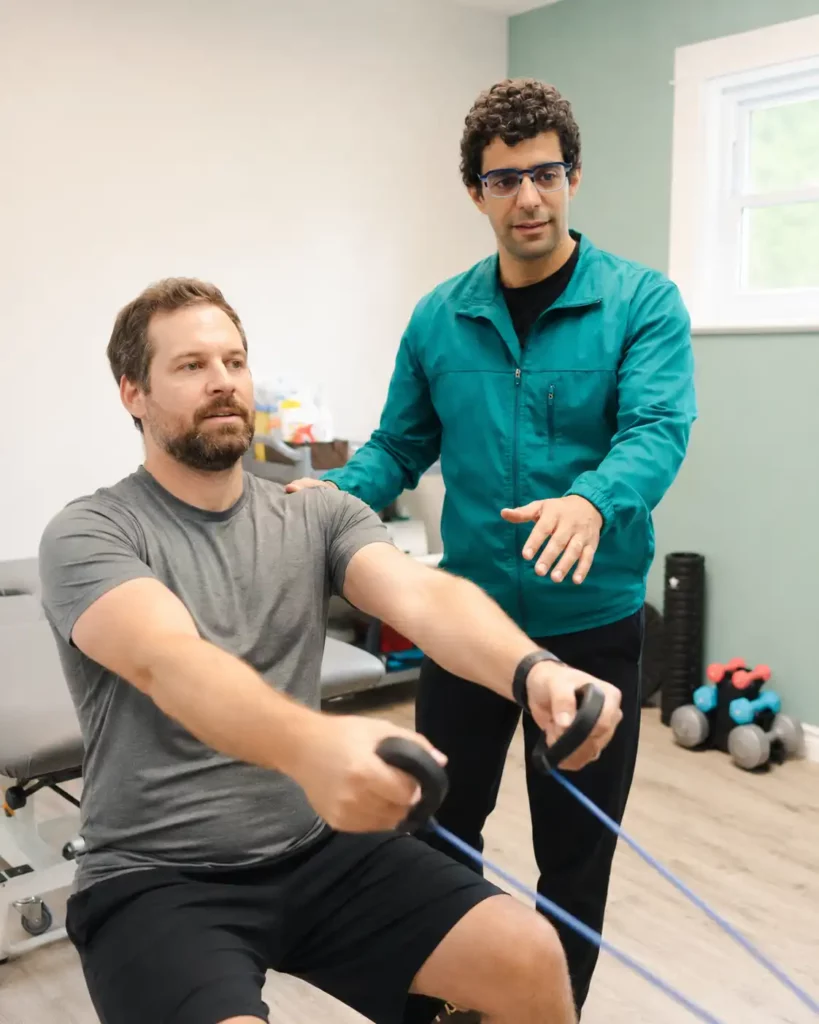 Physiotherapist supervising a seated resistance-band exercise