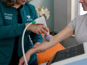 Blog 70 Practitioner applying shockwave therapy to a patient's elbow