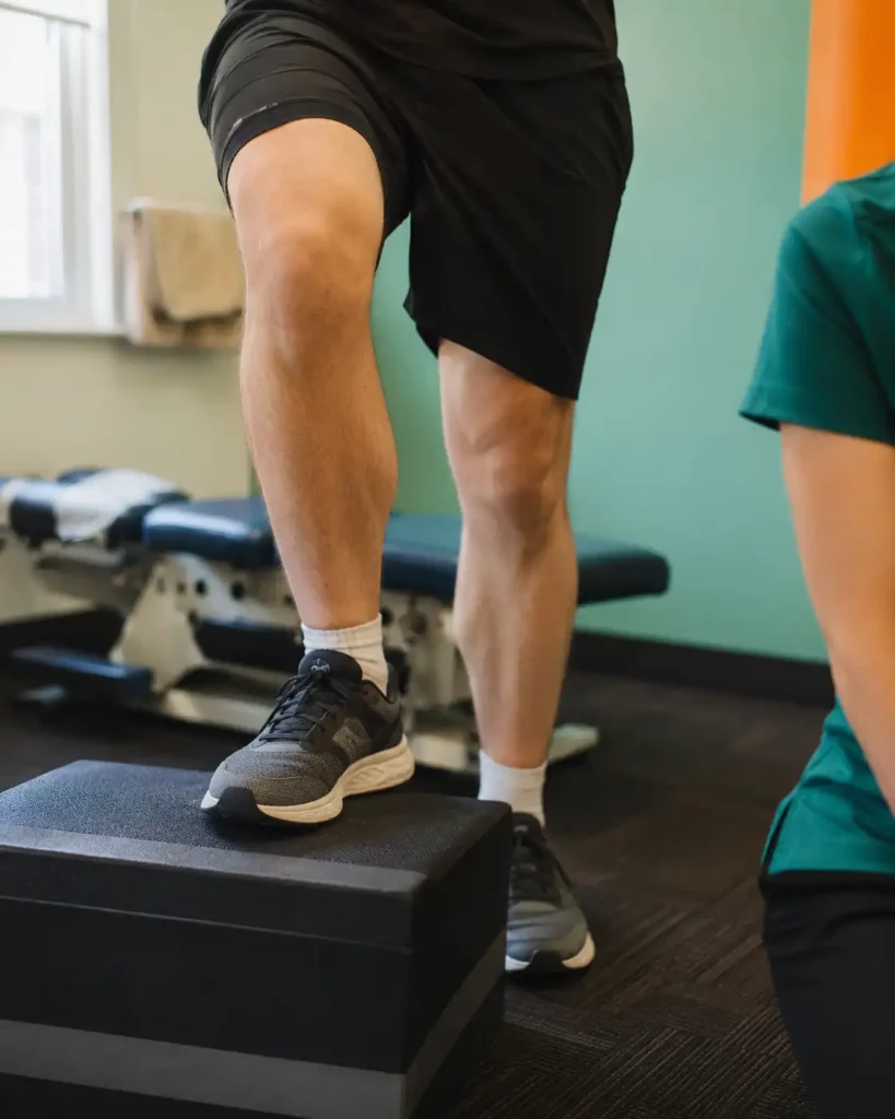 Patient stepping onto a low platform during rehabilitation