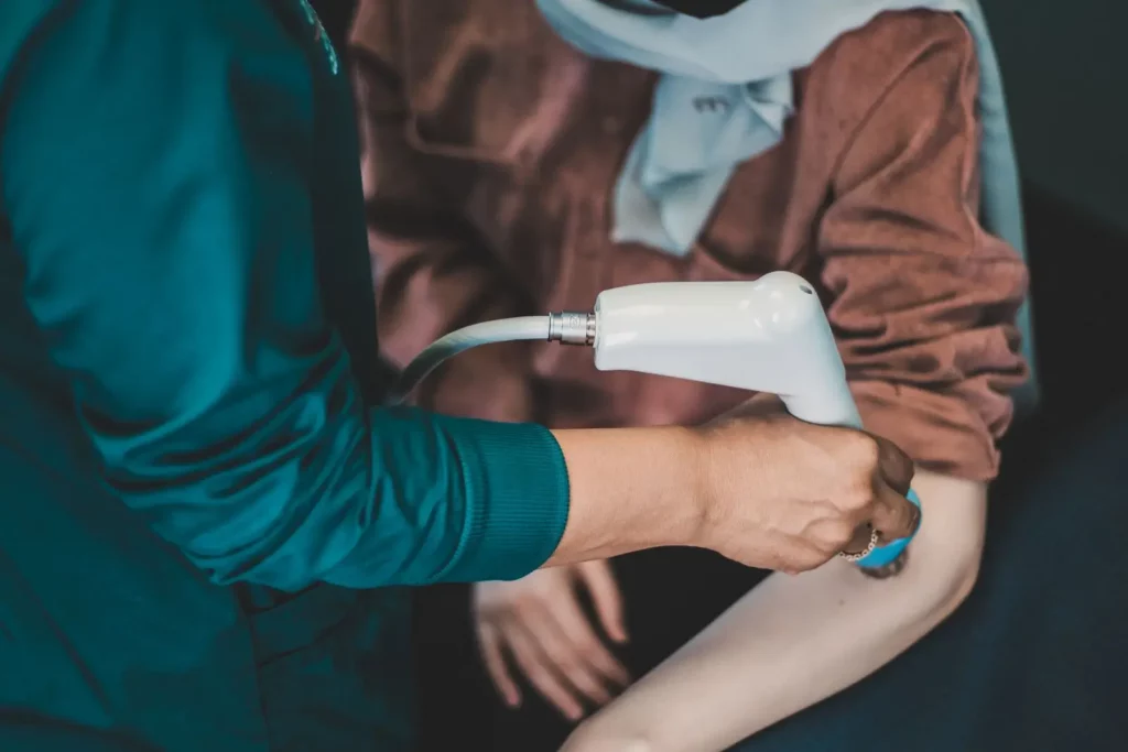 Practitioner applying a handheld therapy device to a patients elbow during golfers elbow treatment at Kent Chiro Med in Ottawa