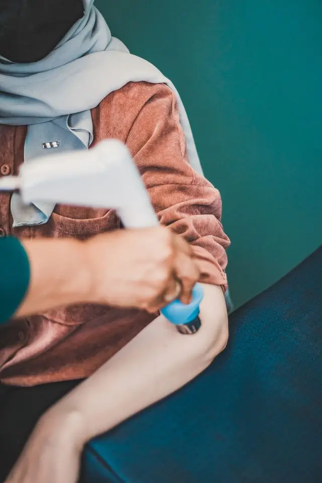 Practitioner applying a shockwave therapy device to a patients elbow during golfers elbow treatment at Kent Chiro Med in Ottawa