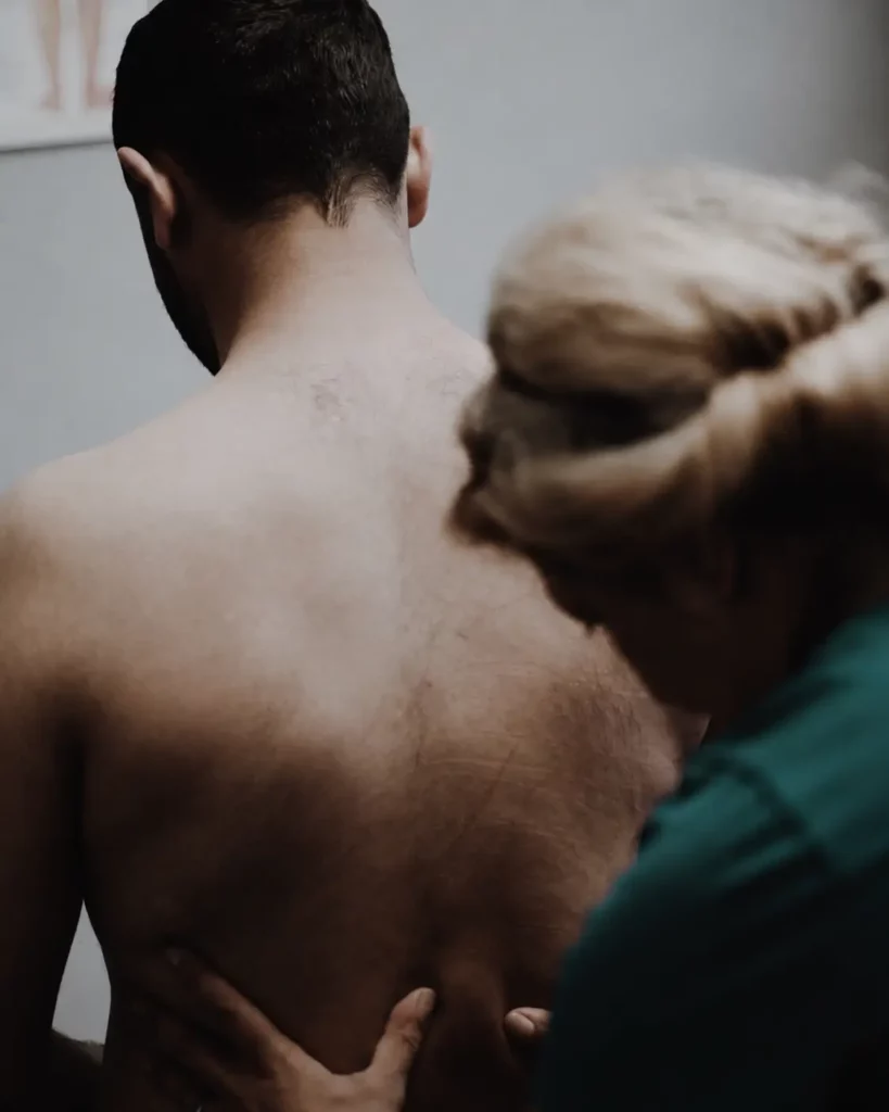 Practitioner applying focused pressure to a patients mid back during trigger point massage in Ottawa