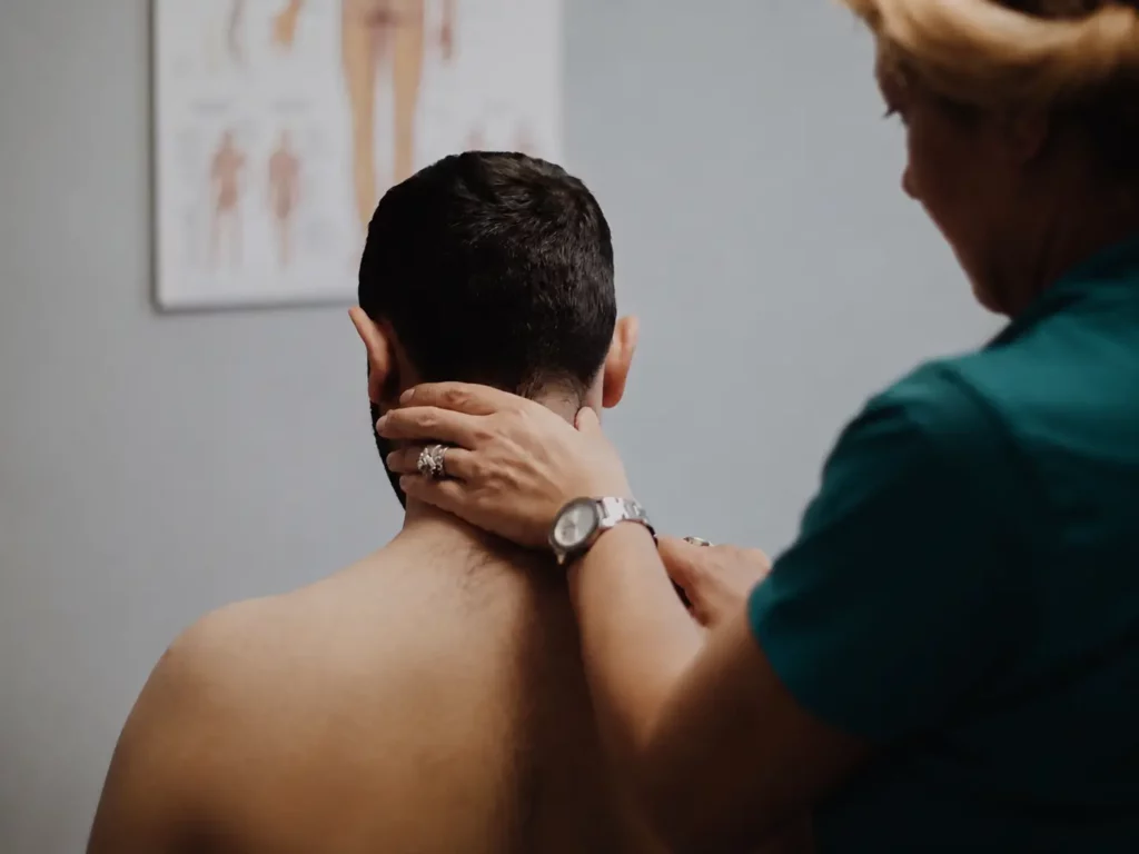 Practitioner applying pressure to a patients neck and upper shoulder during trigger point massage in Ottawa