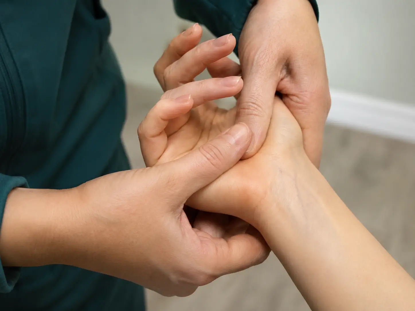Practitioner examining and supporting a patients bandaged hand during carpal tunnel treatment