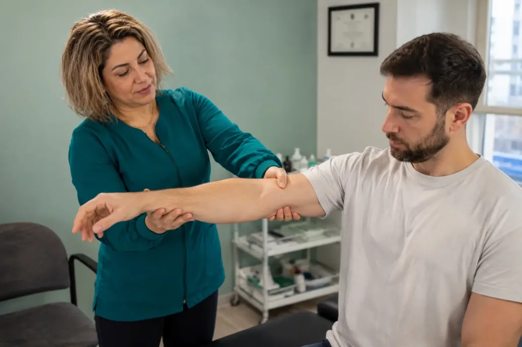 practitioner assessing a patients elbow and forearm during golfers elbow treatment at Kent Chiro Med in Ottawa